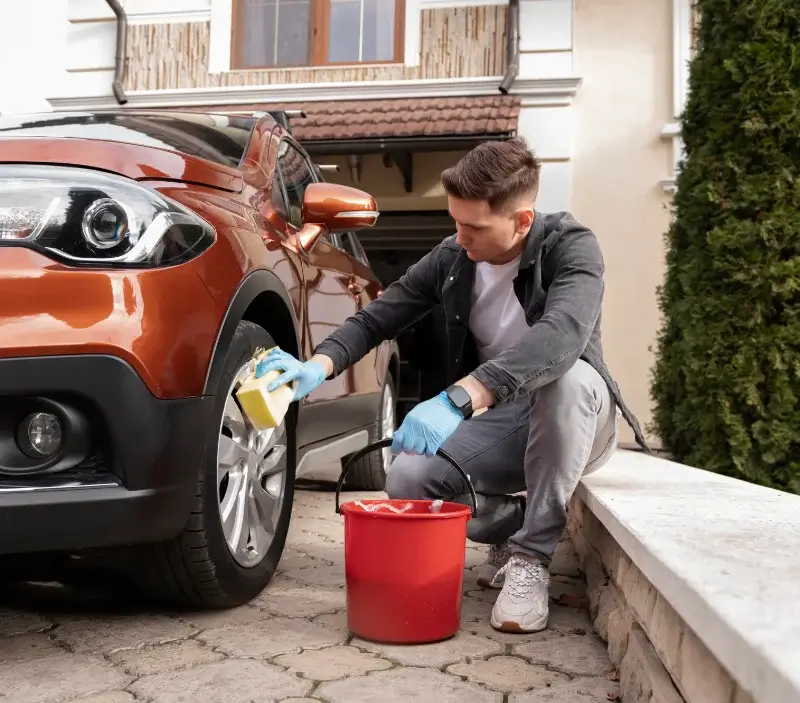Lavage auto à domicile Hauteville-la-Guichard : professionnel intervenant sur un véhicule